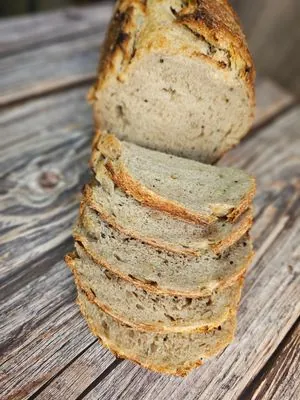 Ancient grain sourdough loaf, sliced on a wooden board